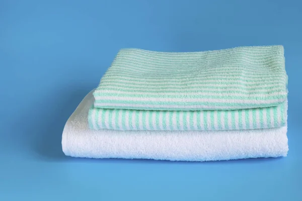 Soft terry cotton towel on a blue background. Bath towel. Personal belongings.