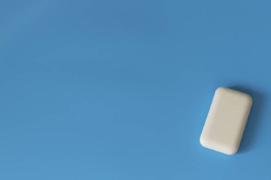 Mavi arka planda sabun. Hijyen ve temizlik. Banyo aksesuarları. Banyo, çamaşır ve vücut bakımı için sabun. Kişisel hijyen ürünleri