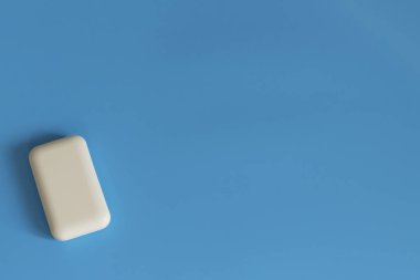 Mavi arka planda sabun. Hijyen ve temizlik. Banyo aksesuarları. Banyo, çamaşır ve vücut bakımı için sabun. Kişisel hijyen ürünleri