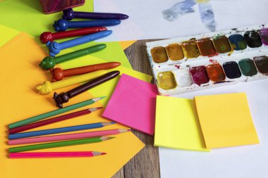 Suluboya, guaj, boya fırçaları, renkli boya kalemleri, çıkartmalar. Çizim, yaratıcılık ve hobiler için hazır..