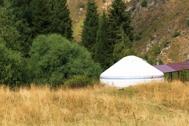 Yurt. Göçebelerin geleneksel evi. Resimli dağlarda bir yurt duruyor. Asya 'ya seyahat.