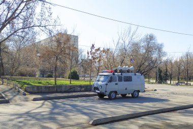 Çatıda hoparlörü olan bir araba tehlike konusunda uyarıyor. Acil Karantina Bilgileri ve Alarm.