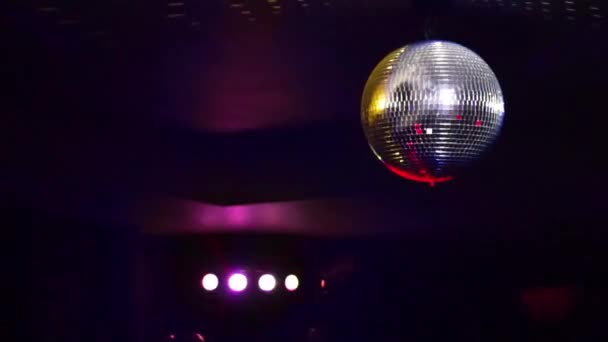 Spiegelkugeln drehen sich und reflektieren Lichter von Projektoren, die durch Rauch in Nachtclub durchbrechen — Stockvideo
