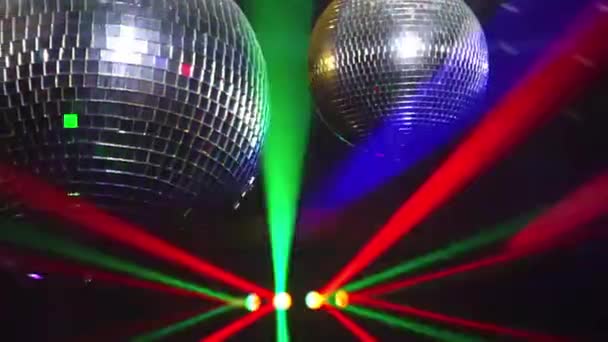 Bolas de espejo giran y reflejan las luces de los proyectores rompiendo el humo en el club nocturno — Vídeos de Stock