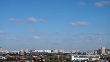 Şehrin yukarısındaki mavi gökyüzünde bulutlar. Timelapse.