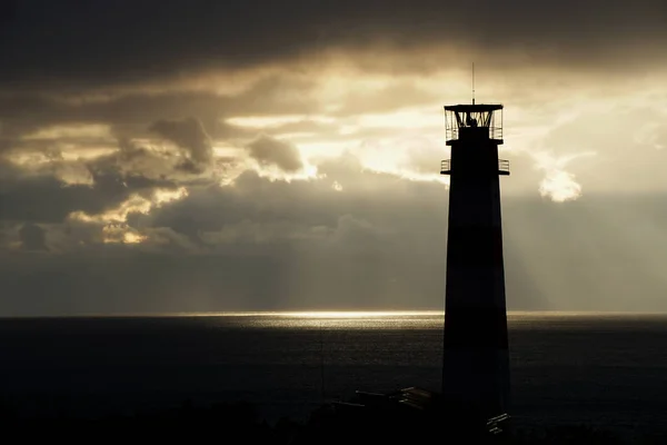 Phare sur la mer sous les nuages orageux au coucher du soleil — Photo