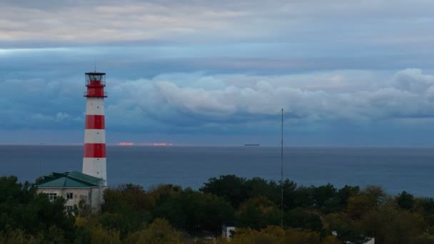 Timelapse маяк на море под штормовыми облаками и с кораблем на заднем плане — стоковое видео