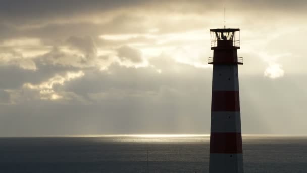 Leuchtturm auf dem Meer unter stürmischen Wolken bei Sonnenuntergang — Stockvideo