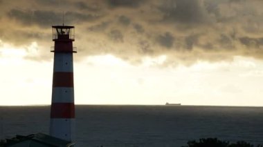 Deniz altında fırtınalı bulutlar ve arka planda gemiyle Timelapse deniz feneri