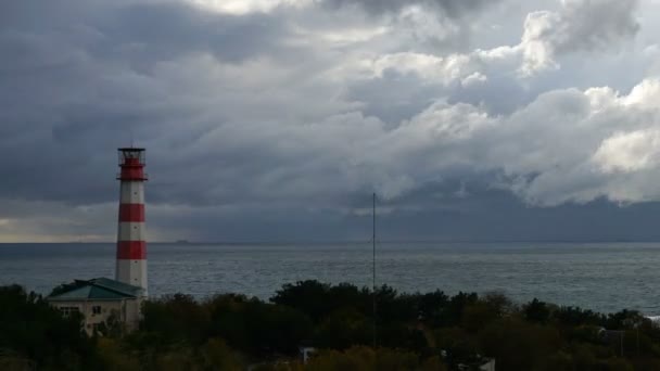 Teherszállító hajó elhalad egy gyönyörű fenséges világítótorony alá drámai viharos felhők — Stock videók