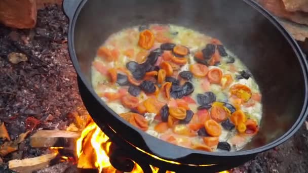 Cucinare la carne in un fuoco nel calderone di ghisa . — Video Stock