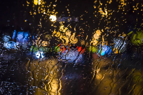 Мокро окно на фоне ночного городского движения . — стоковое фото