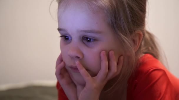 Petite fille la nuit regardant des dessins animés . — Video