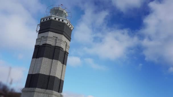 Монохромный маяк на море под небом с облаками на заднем плане — стоковое видео