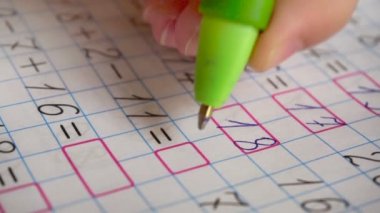 Matematik ödevini yapıyor. Basit örnekler çözer