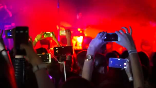 在摇滚音乐会上举行聚会, 用数码显示屏拿智能手机相机 — 图库视频影像