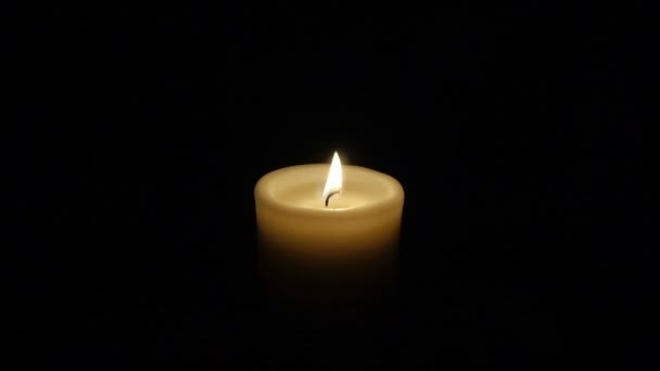 Closeup αναμμένο κερί που απομονώνονται σε μαύρο φόντο. — Αρχείο Βίντεο