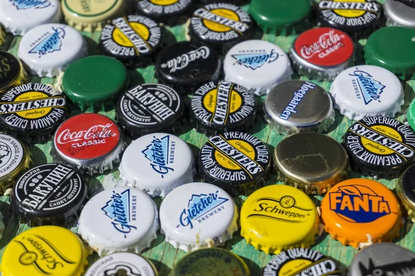 Krasnodar, Russia - April 29, 2018: Beer bottle caps, a mix of global brands: Chesters , Gletcher, Coca-Cola etc. — Stock Photo, Image