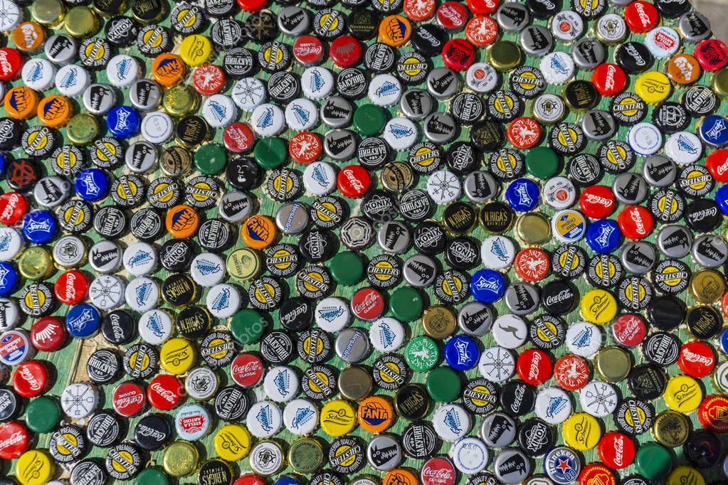 Krasnodar, Russia - April 29, 2018: Background of beer bottle caps, a mix of global brands: Gletcher, Hoegarden, Fanta Schweppes etc