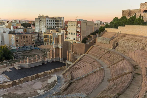 İspanya 'nın liman kenti Cartagena' nın meşhur Roma amfitiyatrosuyla panoramik manzarası. Dağların ardında güzel bir gün batımı. Geniş açı mercek panoraması