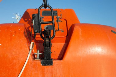 Portakal canlısı kurtarma botunun metal zımbaları denizde acil durum için turuncu botu kurtarıyor, deniz nakil teması. Kapat.