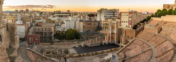 Luchtpanoramisch uitzicht op havenstad Cartagena in Spanje met beroemde Romeinse amfitheater. Prachtige zonsondergang boven de bergen. Panorama groothoeklens — Stockfoto