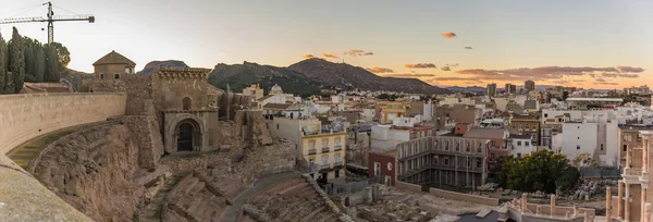 Aerial panoramic view of port city Cartagena in Spain with famous roman amphitheater. Beautiful sunset over the mountains. Wide angle lens panorama