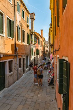 Venedik, İtalya - 02 Ağustos 2019: Venedik 'in dar yaya sokakları. Yerel halk ve turistler tarihi binalar, vitrinler, hediyelik eşyalar, kafeler ve restoranlar boyunca geziniyorlar