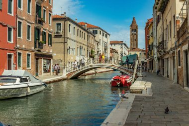 Venedik, İtalya - 02 Ağustos 2019 Venedik 'te güneşli bir günde binlerce güzel köşeden biri. Yerel halk ve turistler demirlemiş teknelerle tarihi binalar ve kanallar boyunca geziniyorlar.