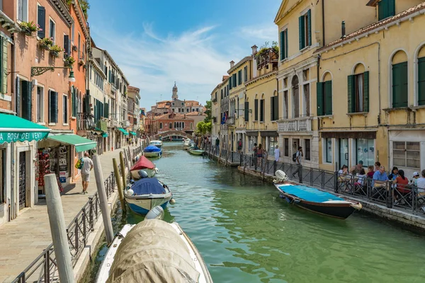 Venetië, Italië - 02 augustus 2019: Een van de duizenden gezellige hoekjes in Venetië op een heldere zonnige dag. Lokalen en toeristen slenteren langs de historische gebouwen en grachten met aangemeerde boten — Stockfoto