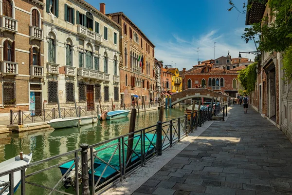 Venetië, Italië - 02 augustus 2019: Een van de duizenden gezellige hoekjes in Venetië op een heldere zonnige dag. Lokalen en toeristen slenteren langs de historische gebouwen en grachten met aangemeerde boten — Stockfoto