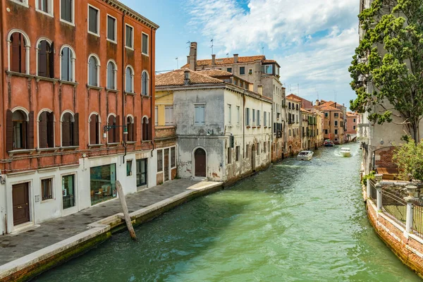 Βενετία, Ιταλία - 2 Αυγούστου 2019: Μια από τις χιλιάδες όμορφες γωνιές της Βενετίας σε μια ηλιόλουστη μέρα. Τοπικοί και τουρίστες που περιδιαβαίνουν τα ιστορικά κτίρια και τα κανάλια με αγκυροβολημένα σκάφη — Φωτογραφία Αρχείου