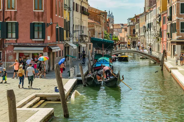 VENICE, ITALY - August 02, 2019: One of the thousands of lovely cozy corners in Venice on a clear sunny day. Locals and tourists strolling along the historical buildings and canals with moored boats — Stock Photo, Image
