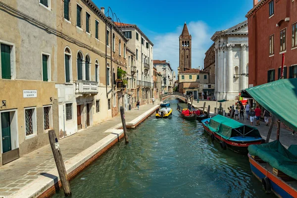 Venedik, İtalya - 02 Ağustos 2019 Venedik 'te güneşli bir günde binlerce güzel köşeden biri. Yerel halk ve turistler demirlemiş teknelerle tarihi binalar ve kanallar boyunca geziniyorlar.