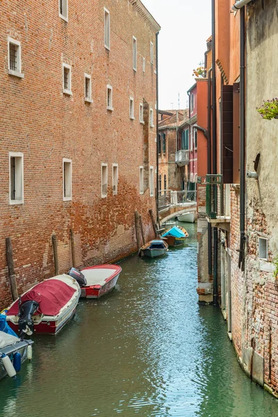 ВЕНИЦИЯ, ИТАЛИЯ - 02 августа 2019 года: Один из тысяч уютных уголков Венеции в ясный солнечный день. Местные жители и туристы прогуливаются по историческим зданиям и каналам с пришвартованными лодками — стоковое фото