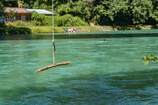 Bern, Svájc - 2019. július 30.: Kilátás az Aare folyóra a napos nyári napon. A helyi lakosok pihenhetnek, napozhatnak és raftingolhatnak felfújható csónakokban a folyó gyors folyása mentén. — Stock Fotó