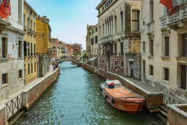 Venedik, İtalya - 02 Ağustos 2019 Venedik 'te güneşli bir günde binlerce güzel köşeden biri. Yerel halk ve turistler demirlemiş teknelerle tarihi binalar ve kanallar boyunca geziniyorlar.