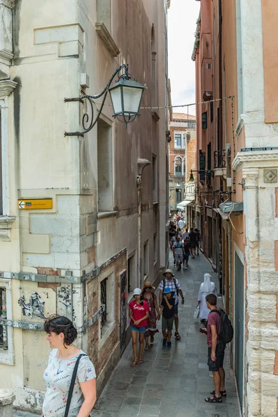 VENECIA, ITALIA - 02 de agosto de 2019: Vista desde el puente de Venecia. Locales y turistas paseando por las estrechas calles peatonales venecianas con edificios históricos, tiendas, cafeterías, restaurantes — Foto de Stock