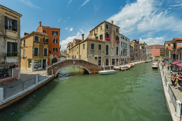 VENICE, ITALY - August 02, 2019: One of the thousands of lovely cozy corners in Venice on a clear sunny day. Locals and tourists strolling along the historical buildings and canals with moored boats — Stock Photo, Image