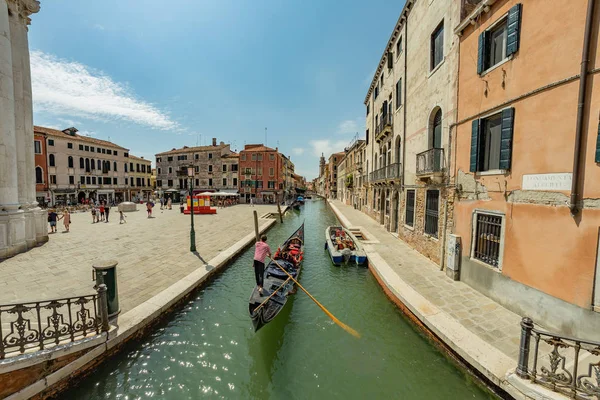 Venedig, Italien - 02. August 2019: eine der tausenden schönen gemütlichen Ecken Venedigs an einem klaren, sonnigen Tag. Einheimische und Touristen flanieren mit festgemachten Booten entlang der historischen Gebäude und Kanäle — Stockfoto