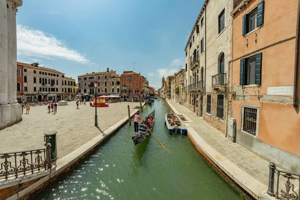 VENICE, ITÁLIA - 02 de agosto de 2019: Um dos milhares de belos cantos aconchegantes em Veneza em um dia ensolarado claro. Locais e turistas passeando pelos edifícios históricos e canais com barcos ancorados — Fotografia de Stock