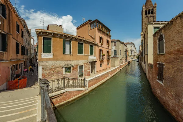 Venetië, Italië - 02 augustus 2019: Een van de duizenden gezellige hoekjes in Venetië op een heldere zonnige dag. Lokalen en toeristen slenteren langs de historische gebouwen en grachten met aangemeerde boten — Stockfoto