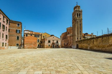 VENICE, ITALY - August 03, 2019: One of the thousands of lovely cozy corners in Venice on a clear sunny day. Locals and tourists strolling along the streets and historical buildings.