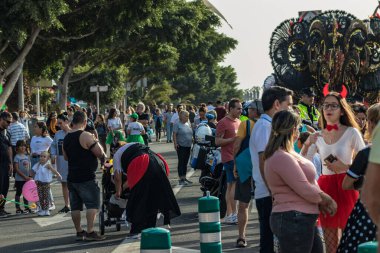 SANTA CRUZ DE TENERIFE, SPAIN - FEBRUARY 25, 2020: Around the Coso parade - along the Avenida de Anaga, official end of Carnival. Amazing warm evening, joyful people in carnival costumes have fun.