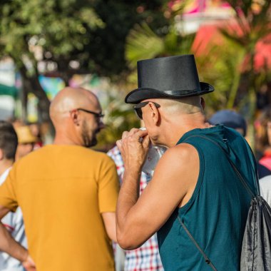 SANTA CRUZ DE TENERIFE, SPAIN - FEBRUARY 25, 2020: Around the Coso parade - along the Avenida de Anaga, official end of Carnival. Amazing warm evening, joyful people in carnival costumes have fun.