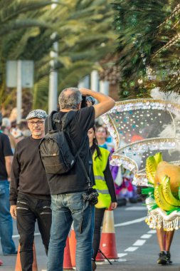SANTA CRUZ DE TENERIFE, SPAIN - FEBRUARY 25, 2020: Around the Coso parade - along the Avenida de Anaga, official end of Carnival. Amazing warm evening, joyful people in carnival costumes have fun.