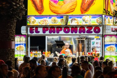 SANTA CRUZ DE TENERIFE, SPAIN - FEBRUARY 25, 2020: Around the Coso parade - along the Avenida de Anaga, official end of Carnival. Amazing warm evening, joyful people in carnival costumes have fun.