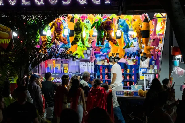 SANTA CRUZ DE TENERIFE, SPAIN - FEBRUARY 25, 2020: Around the Coso parade - along the Avenida de Anaga, official end of Carnival. Amazing warm evening, joyful people in carnival costumes have fun.