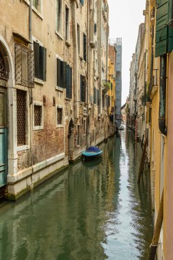 VENICE, ITALY - August 02, 2019: One of the thousands of lovely cozy corners in Venice on a clear sunny day. Narrow channel surraunded by the historical buildings.