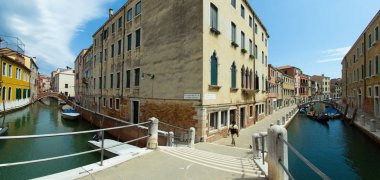 Venedik, İtalya - 02 Ağustos 2019 Venedik 'te güneşli bir günde binlerce güzel köşeden biri. Yerel halk ve turistler demirlemiş teknelerle tarihi binalar ve kanallar boyunca geziniyorlar..